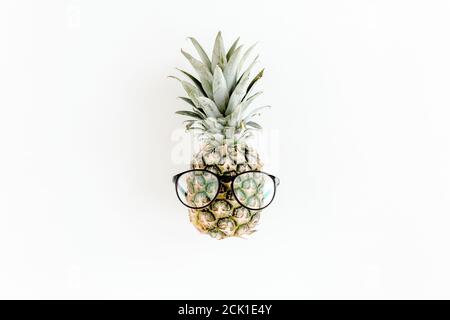 Hipster pineapple in glasses on white background. Flat lay, top view Stock Photo