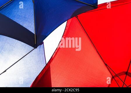 Fabric of an intense red and blue  umbrella. Stock Photo