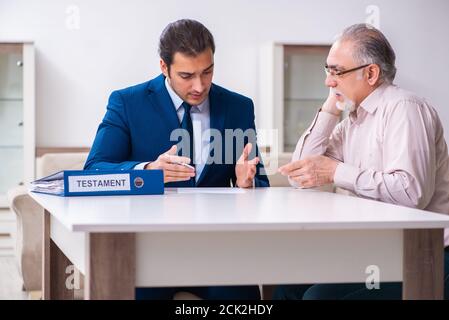 Young lawyer visiting old man in testament concept Stock Photo