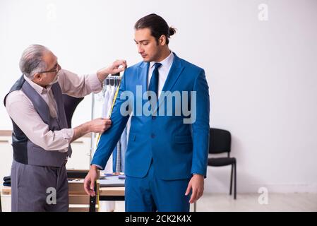 Young businessman visiting old tailor Stock Photo