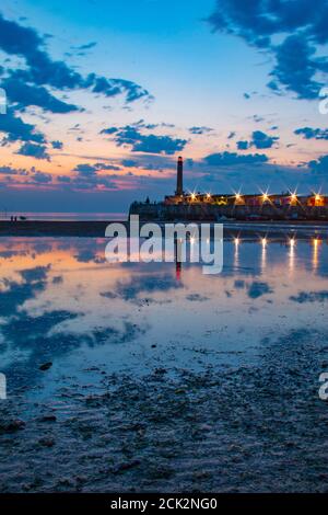 Beautiful reflection of the sunset and lighthouse in the low tide at Margate Harbour Arm - Margate, Thanet, Kent, England, United Kingdom Stock Photo