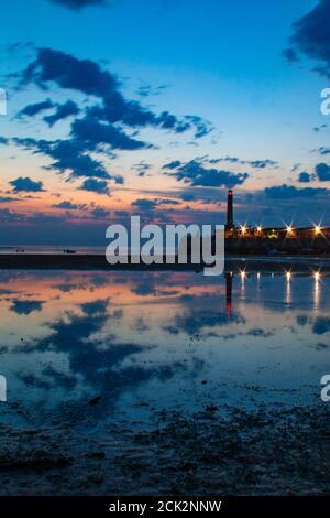 Beautiful reflection of the sunset and lighthouse in the low tide at Margate Harbour Arm - Margate, Thanet, Kent, England, United Kingdom Stock Photo