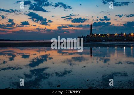 Beautiful reflection of the sunset and lighthouse in the low tide at Margate Harbour Arm - Margate, Thanet, Kent, England, United Kingdom Stock Photo