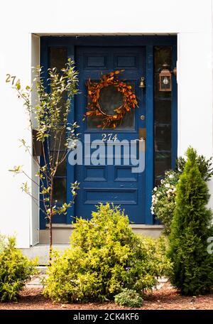 A blue front door decorated for fall on a white house in West Acton, Massachusetts, USA. Stock Photo