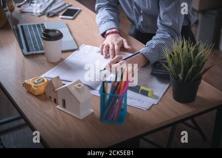 Architect Woman is Working Architecture Drawing Layout and Detail Drafting on Table Desk in Home Office, Female Designer is Creative Sketching for Con Stock Photo