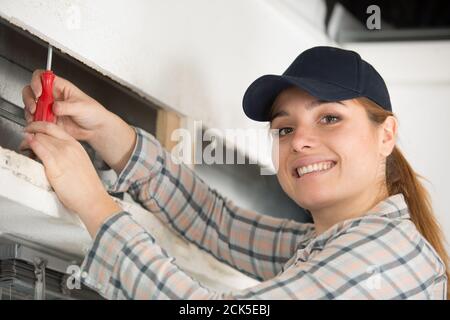 woman installing blinds with screwdriver Stock Photo