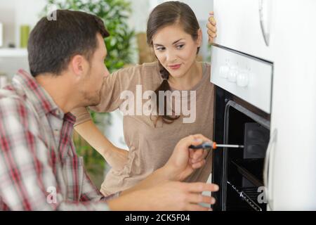 woman with contractor at kitchen discussing repair Stock Photo