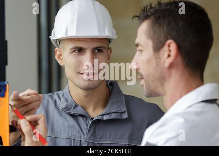 construction workers installing window in house Stock Photo