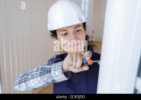 woman installing blinds with screwdriver Stock Photo