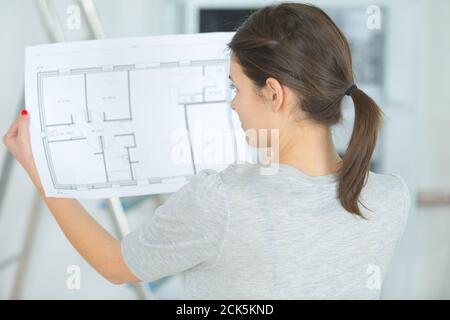 thoughtful female architect looking on blueprint Stock Photo