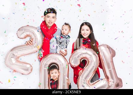 happy family having fun with sign 2021 made of silver balloons for new year Stock Photo