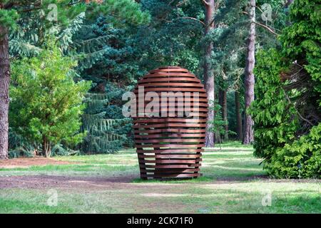 Metal head sculpture in the pinetum at RHS Wisley Gardens, Surrey, England Stock Photo