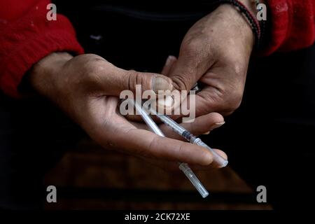 A heroin addict, who didn't want to be identified, displays needles used for shooting heroin near the Law School building at the University of Athens, Greece, October 24, 2018. REUTERS/Costas Baltas