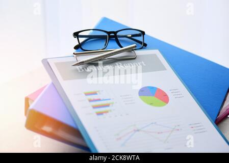 Business graph chart report paper financial document and file with  pen and glasses on desk Stock Photo