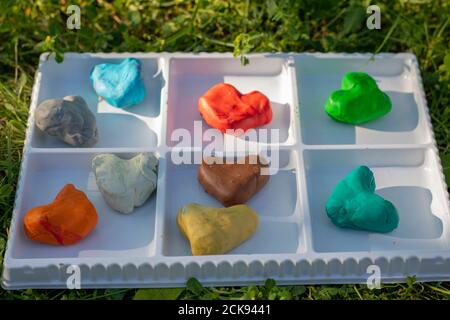 Many colored clay dough hearts in white box Stock Photo