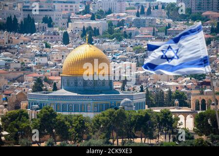 An Israeli flag blows in the wind from the mount of olives overlooking the old city of Jerusalem, Israel. Jerusalem is the most visited city in Israel Stock Photo