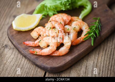 Salad shrimp grilled delicious seasoning spices on wooden cutting board background appetizing cooked shrimps baked prawns , Seafood shelfish with rose Stock Photo