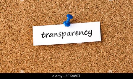 Transparency. Word written on a piece of paper or note, cork board background.