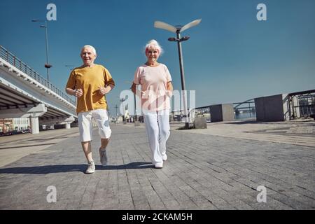 Sporty pensioners working out on the river bank Stock Photo