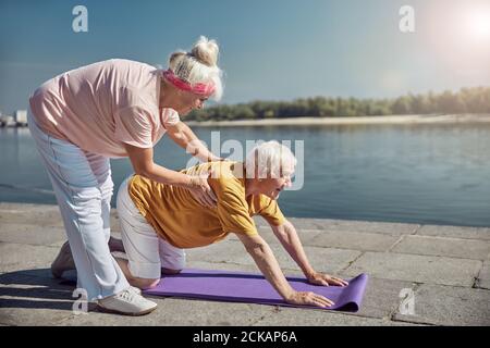 Smiling senior beginner yogi working out outside Stock Photo