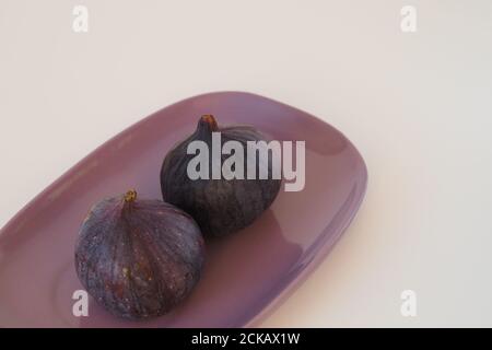 The figs are purple on an oval platter. Stock Photo
