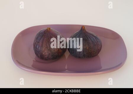 The figs are purple on an oval platter. Stock Photo