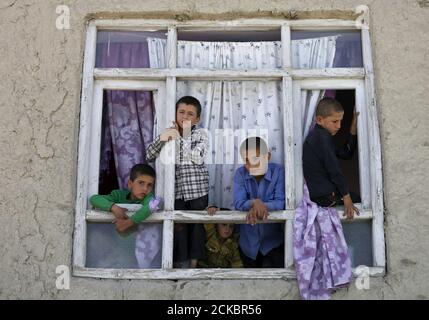 Children look out from the broken window of a house near the site of a car bomb blast at the entrance gate to Kabul airport, Afghanistan August 10, 2015.  A car bomb exploded near the entrance to Kabul airport on Monday, killing at least four people and wounding 17, days after a series of suicide attacks in the Afghan capital killed dozens and wounded hundreds.    REUTERS/Mohammad Ismail      TPX IMAGES OF THE DAY