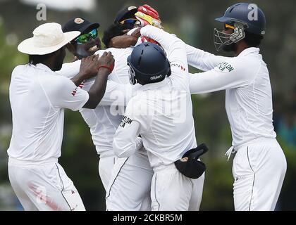 Sri Lanka's Tharindu Kaushal (C) celebrates with captain Angelo Mathews (2nd L) and Dinesh Chandimal (R) after taking the wicket of India's Shikhar Dhawani (not pictured) during the fourth day of their first test cricket match against Sri Lanka in Galle August 15, 2015. REUTERS/Dinuka Liyanawatte