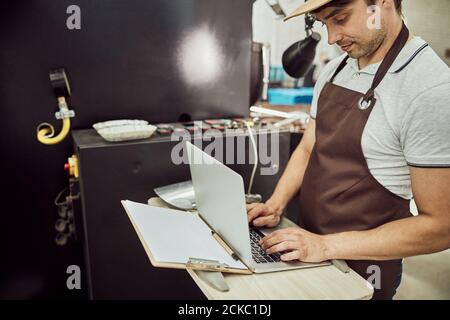 Handsome male worker using modern laptop at work Stock Photo