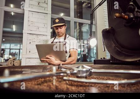 Handsome young man professional roaster using notebook at work Stock Photo