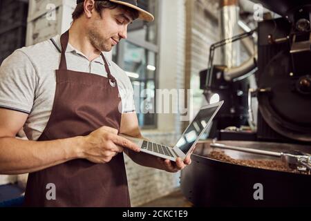 Handsome young man roaster using laptop at work Stock Photo