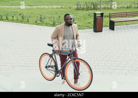 African young man standing with his bike on the street he is going to ride Stock Photo