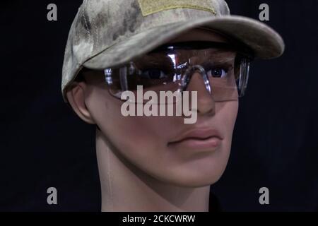 Mannequin face in a military cap and protective glasses isolated on a black background Stock Photo