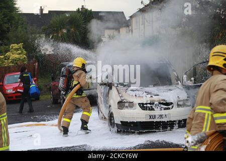 Belfast, Northern Ireland, UK. 15 Sept, 2020. Northern Ireland Fire and Rescue Service put two cars set alight at the rear of homes in the Rossnareen Avenue area of west Belfast. CAr where abandon moments early..Credit: Paul McErlane