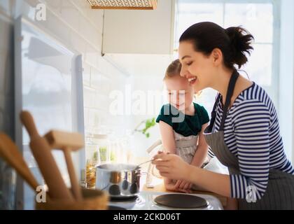 Healthy food at home. Happy family in the kitchen. Mother and child daughter are preparing proper meal. Stock Photo