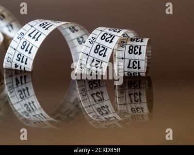 Tape measure, used by dressmakers and tailors to take measurements of the clothes to be made. Stock Photo
