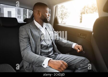 Elegant african american businessman looking through car window Stock Photo