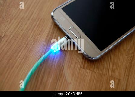 mobile phone charger charging cable with blue light Stock Photo