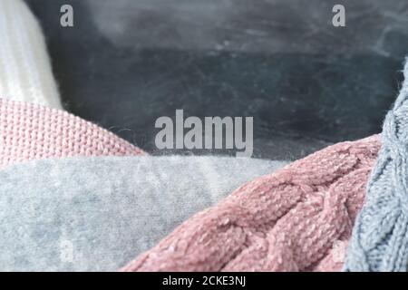 winter textile frame made of knitted sweaters in pink and grey colors. warm pullovers for autum. copy space for text or advertizing. cold season sale template. Stock Photo