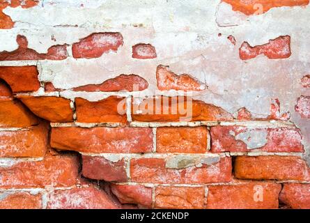 Brick cracked old weathered wall with an old plaster as a background Stock Photo