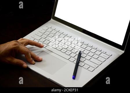 Close-up of a man typing on laptop keyboard against black background Stock Photo