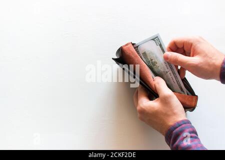 man takes out money from a purse on a white background with space for text Stock Photo