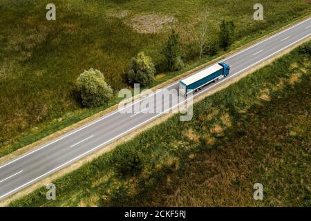 Large freight transporter semi-truck on the road, aerial view from drone pov Stock Photo