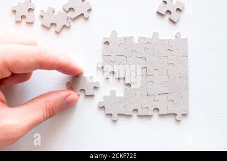 hand holding the correct part of the puzzle on a white background Stock Photo