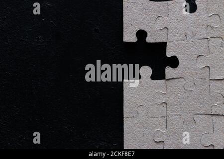 The last missing piece in a puzzle on a black background with space for text. Stock Photo