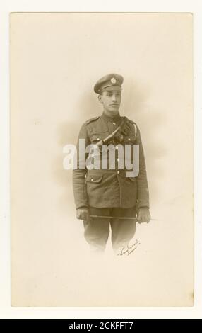 WW1 era studio portrait photograph of handsome young cavalry man soldier, wearing a bandolier or bullet belt, carrying a cane whip, Blackheath, London, England, U.K. 1914-.1918 Stock Photo