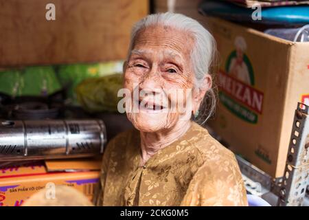 Ho Chi Minh / Vietnam - January 25, 2020: portrait of pretty old vietnamese woman with many wrinkles on her face smiling at camera Stock Photo