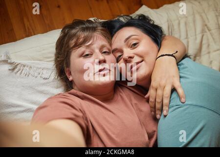 Two lesbians embracing each other and posing at camera they making selfie portrait Stock Photo