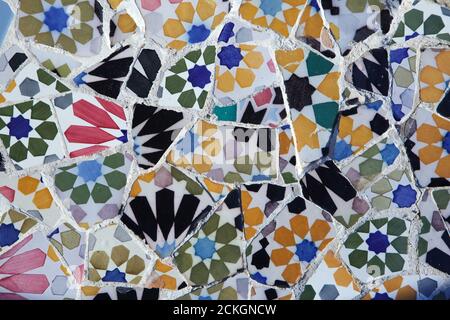 Trencadís mosaic work on the terrace in the Park Güell designed by Catalan modernist architect Antoni Gaudí and built between 1900 and 1914 in Barcelona, Catalonia, Spain. Stock Photo
