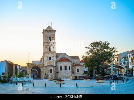 Saint Lazarus church at Larnaka square in evening light, cafes and shops at tiusristic street, Cyprus Stock Photo